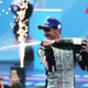 A photo of Sébastien Buemi spraying Champagne on the Formula E podium.